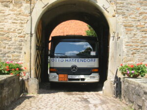 Ein Tankwagen von Otto Hattendorf fährt durch eine Tordurchfahrt in einer alten Stadtmauer